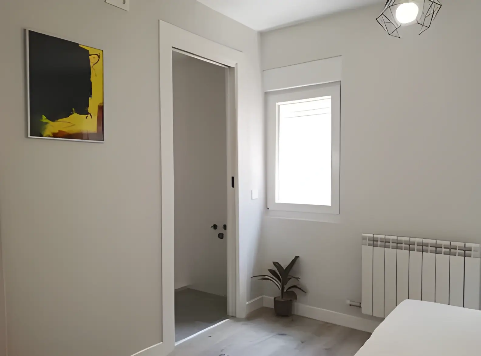 Habitación recién pintada en blanco por Los Pintores Segovia para comunidad de vecinos